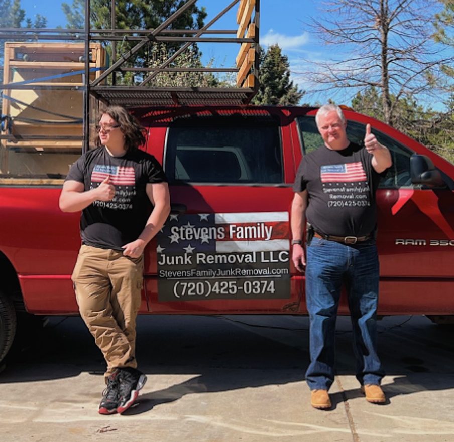 Red pickup truck with wooden frames and mesh structure loaded in the truck bed.